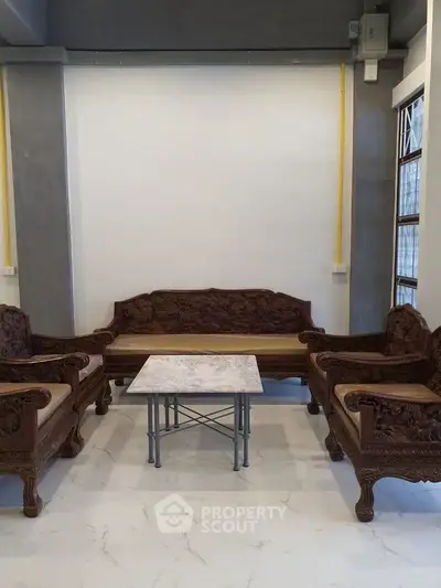 Elegant living room with carved wooden furniture and marble table