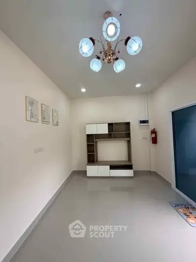 Spacious living room with modern chandelier and sleek storage unit