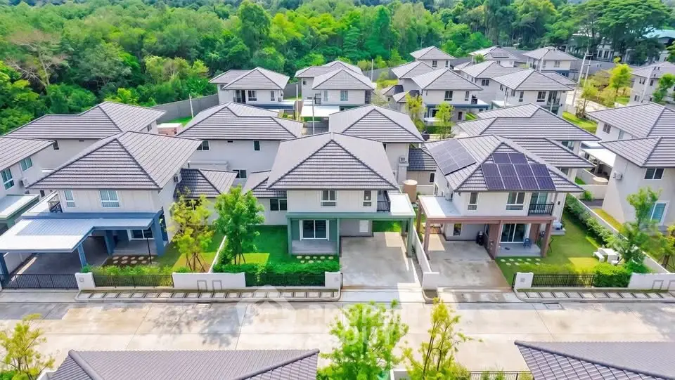 Aerial view of modern suburban homes with lush greenery, showcasing a peaceful residential neighborhood.