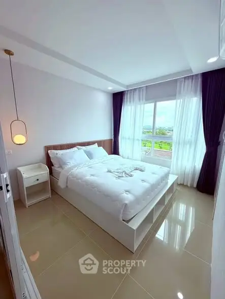 Bright and airy bedroom with large window and modern decor, offering a serene and inviting atmosphere.