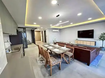 Modern open-layout living room with sleek kitchen and elegant dining area.