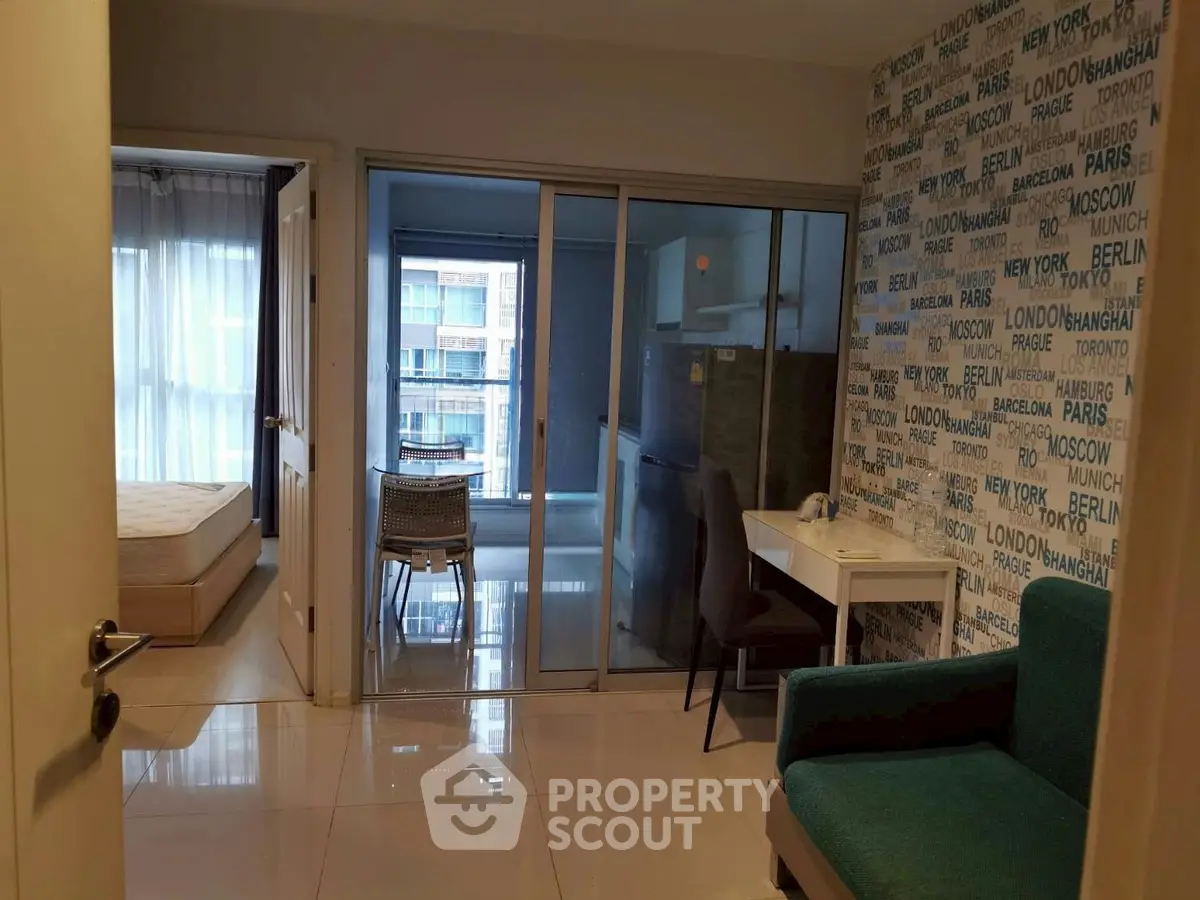 Modern apartment interior with stylish decor and city-themed wallpaper, featuring a cozy living area and bedroom view.