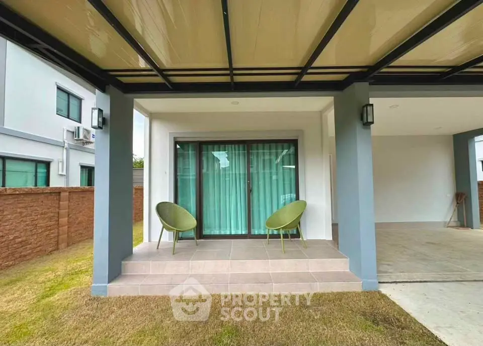 Modern house exterior with covered patio and green chairs