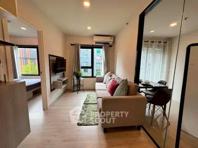 Modern living room with cozy sofa, wall-mounted TV, and dining area in stylish apartment.