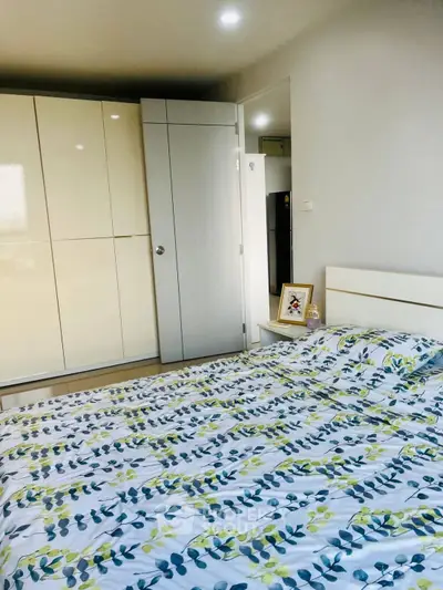 Bright bedroom with modern wardrobe and floral bedding, perfect for cozy living.