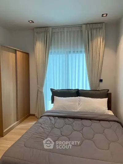 Cozy bedroom with modern decor and large window for natural light