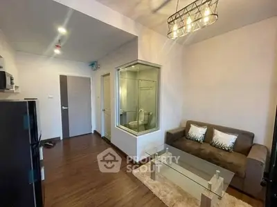 Modern living room with glass partition and stylish lighting in a cozy apartment.