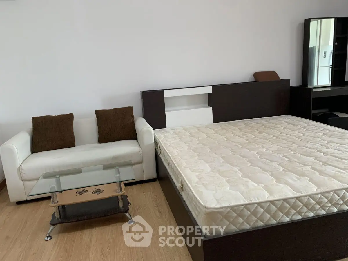 Spacious bedroom with modern furniture and cozy seating area