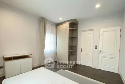 Spacious bedroom with modern design and ample natural light, featuring built-in wardrobe and elegant decor.