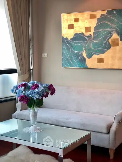 Elegant living room with modern art and plush sofa, perfect for relaxation and style.