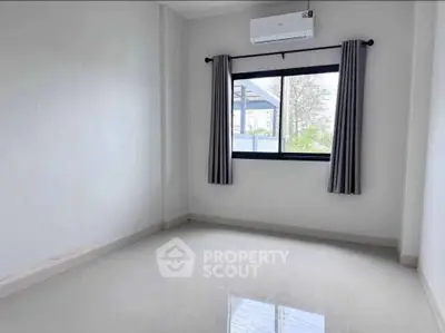 Bright empty room with large window and air conditioning, perfect for customization.