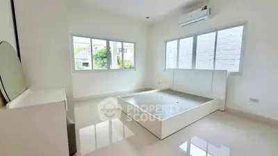 Spacious bedroom with large windows and modern air conditioning unit.