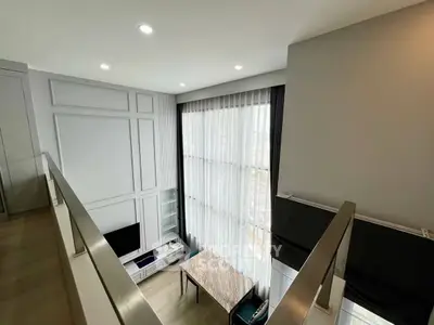 Modern loft-style living room with high ceilings and large windows