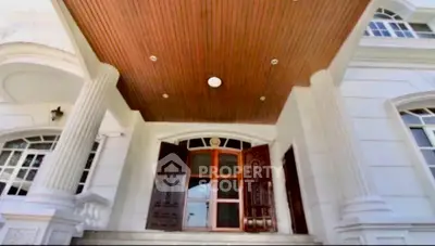Elegant entrance of a luxury building with grand wooden doors and classic architectural details.
