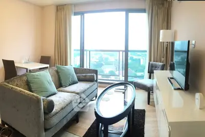Modern living room with panoramic city view, stylish furniture, and natural light.