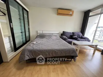 Modern bedroom with sleek furniture and large window offering natural light.
