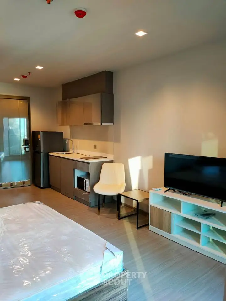 Modern studio apartment with sleek kitchen and cozy living area, perfect for urban living.