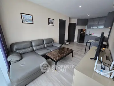 Modern living room with sleek furniture and open kitchen layout in a stylish apartment.
