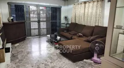 Spacious living room with marble flooring and large brown sectional sofa
