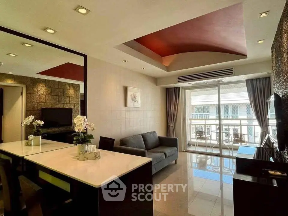 Modern living room with stylish ceiling design and balcony view in luxury apartment.