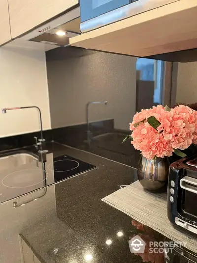 Modern kitchen with sleek black countertops and elegant floral decor