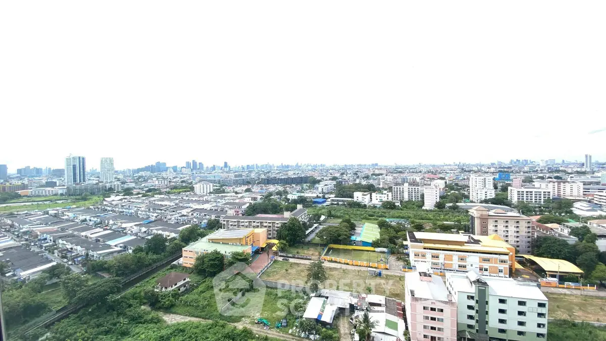 Stunning panoramic cityscape view from high-rise apartment, showcasing urban skyline and lush greenery.