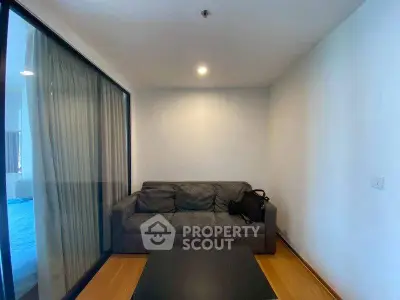 Cozy living room with modern sofa and glass partition in stylish apartment