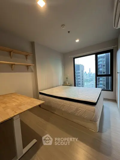 Modern bedroom with city view, featuring minimalist design and wooden flooring.