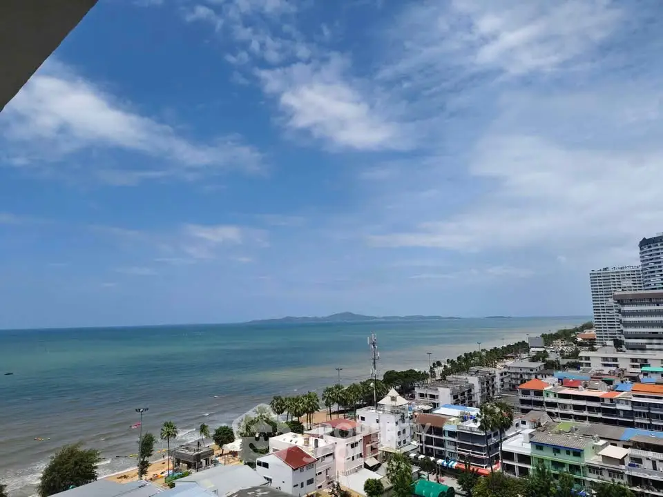 Stunning coastal view from high-rise building overlooking ocean and beachfront properties.