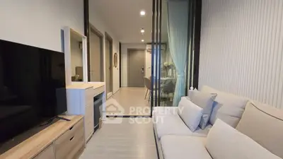 Modern living room with sleek design and glass partition leading to dining area.