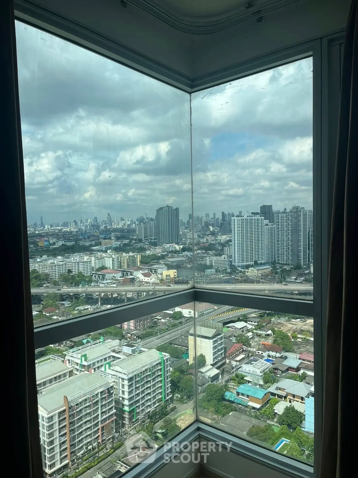 Stunning corner unit with panoramic city views from high-rise window.