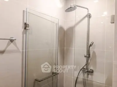 Modern bathroom with sleek glass shower enclosure and chrome fixtures.