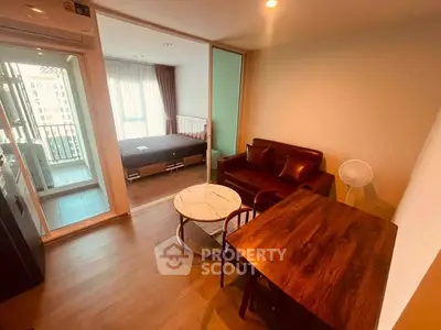 Modern apartment interior with cozy living room and bedroom, featuring wooden furniture and a balcony view.
