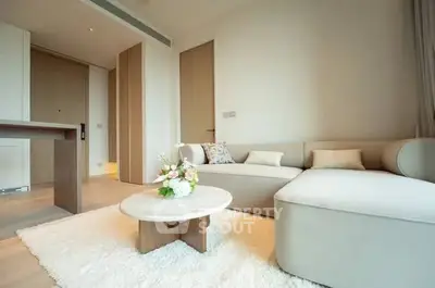 Modern living room with elegant beige sofa and stylish coffee table in a bright, minimalist apartment.