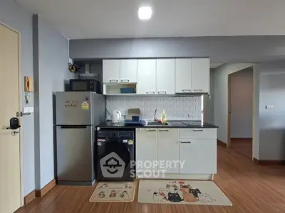 Modern kitchen with sleek white cabinets and appliances in cozy apartment