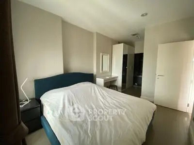 Spacious bedroom with modern furnishings and ample natural light, featuring a cozy bed and sleek wardrobe.