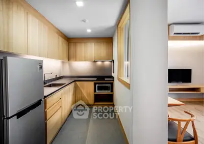 Modern kitchen with sleek wooden cabinetry and stainless steel appliances