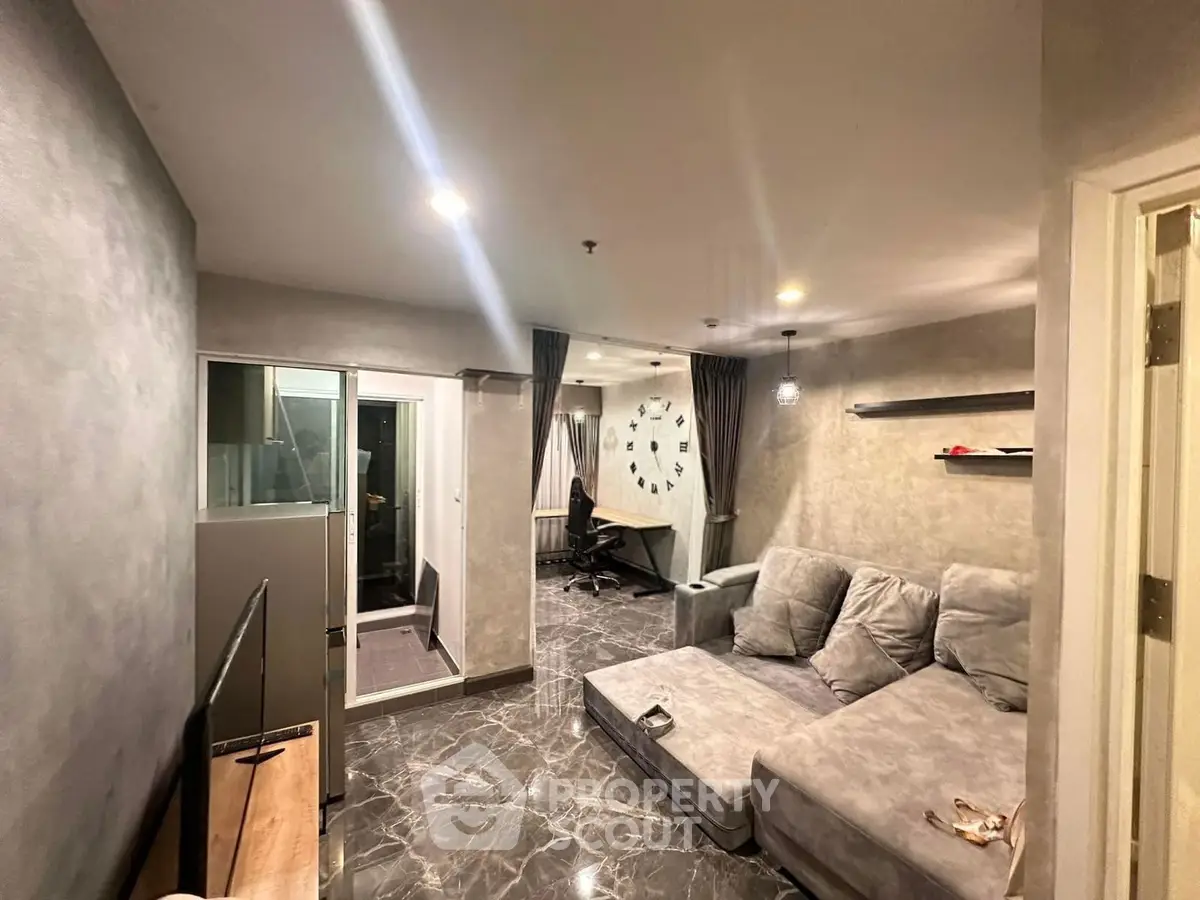Modern living room with stylish gray sofa and marble flooring, featuring a study nook and contemporary decor.
