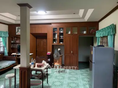 Charming living area with wooden cabinetry and vintage decor, featuring a cozy dining space and a classic fridge.