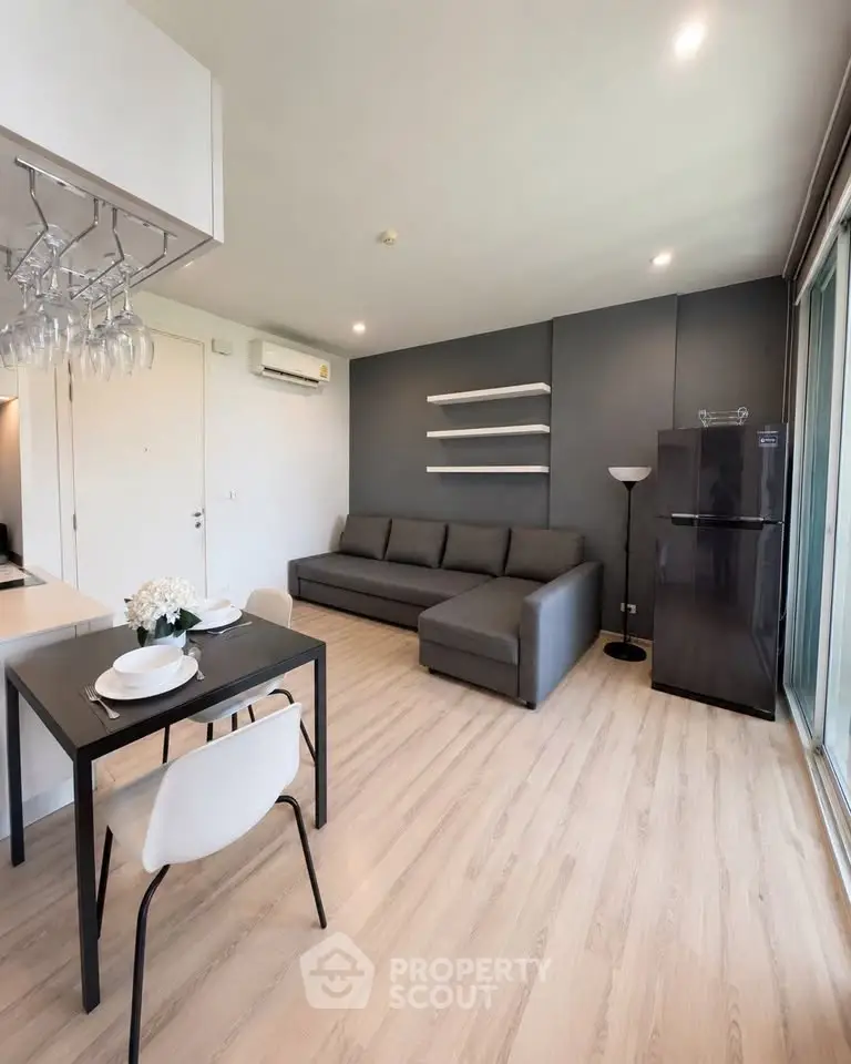 Modern living room with sleek furniture and open layout, featuring a cozy sofa and dining area.