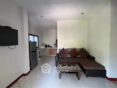 Cozy living room with modern kitchenette and stylish sofa, perfect for urban living.