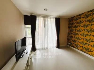 Spacious living room with large window and stylish wallpaper, perfect for modern living.