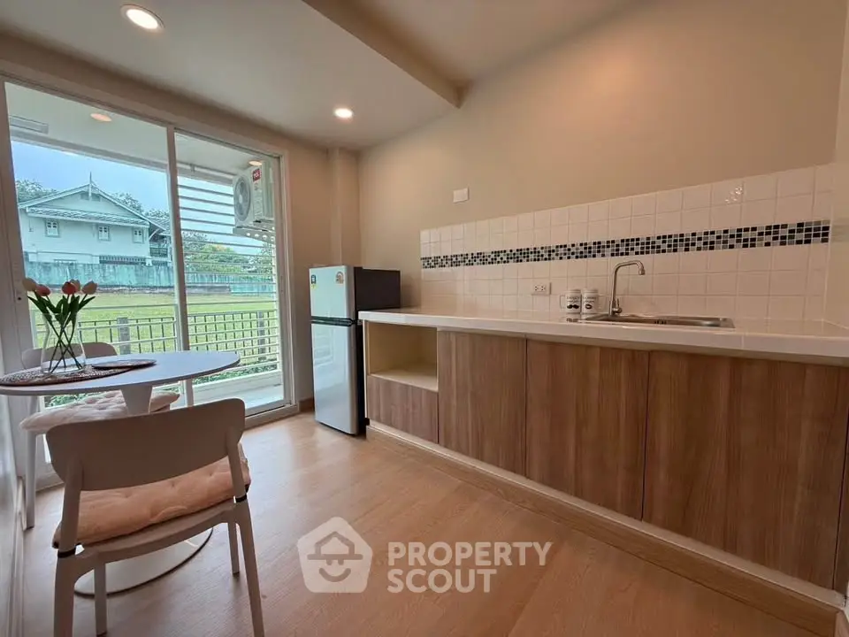Charming kitchen with open layout and scenic view, featuring modern appliances and cozy dining area.