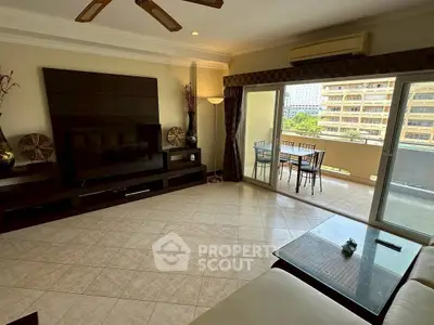 Spacious living room with balcony access and modern decor in urban apartment.