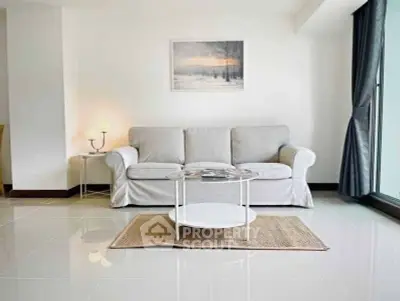 Bright and modern living room with elegant sofa and large window view.