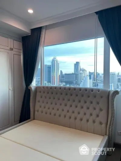 Luxurious bedroom with stunning city view and elegant tufted headboard