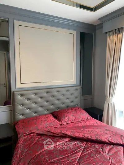 Luxurious bedroom with elegant decor and plush red bedding in a modern apartment.