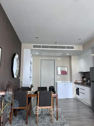 Modern open-layout living room with dining area and sleek kitchen design.