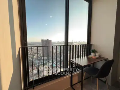 Stunning high-rise apartment with breathtaking city view from a cozy balcony workspace.