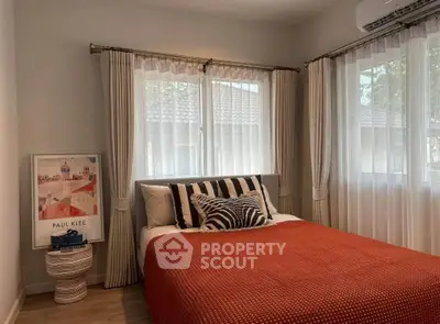 Cozy bedroom with stylish decor and natural light, featuring a comfortable bed and elegant curtains.